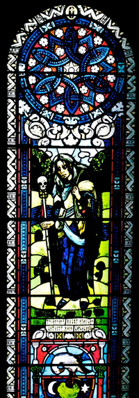 A stained glass window depicting a sad man, at the Defence Against the Dark Arts staircase.