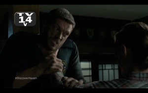 Duke chokes Dwight, holding him off the ground.