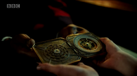 Lyra holding the alethiometer