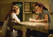 Lacey Rivers and Camille Gardner sitting at a table in prison