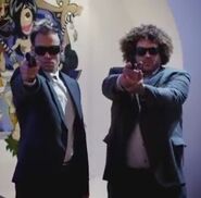 Two secret agents pointing their loaded guns at Kevin Freeman and Alexis