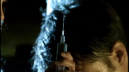 Violet holds a syringe in her hand while interrogating Foster Prentiss