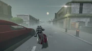 A Helldiver scouts the streets of one of Alderidge Cove's urban settlements, the planet's moon ominously overlooking the foggy streets