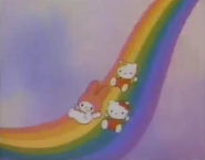 Kitty, Mimmy, and My Melody sliding on a rainbow.