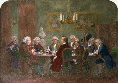 Dining room with nine men seated around a table. The dinner has been finished, and a large man at the head talks and gesticulates while the others eagerly listen. The men wear wigs and clothing of late 18th century Britain, and the furniture, hangings, and chandelier are of similar vintage. A liveried servant is entering with a tray bearing two high-shouldered decanters of wine.
