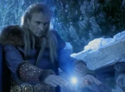 Baldor channels 'energy' through a healer to heal a villager who's dying 