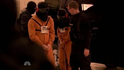 A hooded Hiro being led out of the van