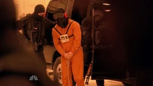 A hooded Matt being dragged out of a van.