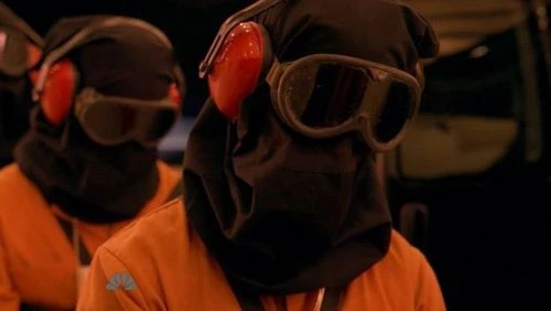Female fugitive, hooded and drugged (behind her are hooded fugitive and Mohinder)