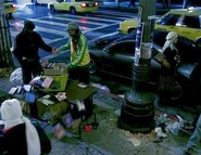 Peter and Claude's invisible struggle upsets items on a street vendor's table. (Godsend)