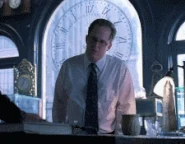 Brian moves a cup across a table in Gabriel Gray's watch repair shop. (Six Months Ago)