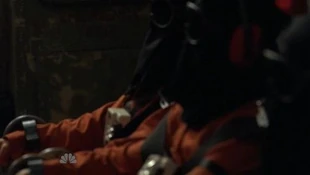 Hooded prisoners are seated while Claire tries to sneak inside the plane (2nd prisoner from left is Peter and on his right is Mohinder)