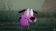 Courage witnessing in fear as Scooby-Doo's giant fist comes towards him.