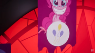 Discord flying through the banner of Pinkie Pie.