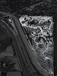 View of the RKO "Back 40" lot in Culver City, 1965, looking west. The Stalag 13 set is near the northwest corner, which is beside the junction of Higuera Street to the north and Lucerne Avenue to the west. Palm trees along Lucerne and the water tower at Desilu Studios were visible in numerous episodes.