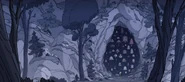 When fleeing, she stumbles upon a cave with tons of bells in front of the entrance.