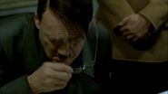 Hitler takes off his glasses when Mohnke finishes pointing at the map.