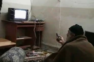Osama Bin Laden watching TV in his hideout.
