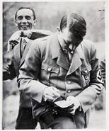 The real Goebbels having some fun playing antics on Hitler's back.
