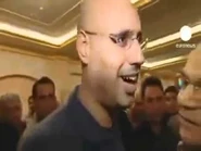 Saif becomes Goering and prepares to gobble the man on the right