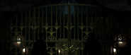 Sergei Zavorotko and the Mystery Man meet outside of the Asylum, with the insignia on the gates.