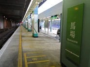 東鐵綫的直式站牌，左邊有橫式燈箱站牌（馬場站）