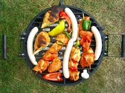 lots of different items on a round, portable style grill ("barbecue art")