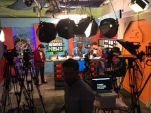 An SJNews set photo from the channel's early days. The photo depicts the camera and lighting set-up.