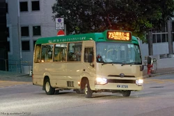 A  diesel green minibus with a  on the front displaying route number and destination