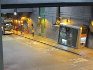 落客站旁的通道、設有扶手電梯前往高架行人通道（2012年8月）