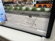 採用新款ADL車廠的巴士的車窗標記，九巴 AED 車窗的玻璃標籤，「V」代表非擋風玻璃，透光度少於 70%