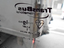 九巴2003年ATE的車窗標記，印有「英國標準」雙半球雪糕圖案