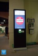 九巴大專優惠站頂部為班次顯示屏，優惠機設計與「九巴 一拍即慳」計劃相近，但改用零售商戶款式的白色讀寫器