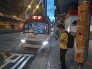 此路線小巴在銀行中心候客（2020年5月）。由於正值日出，此車抵達西環後會隨即改為提供日間行走西隧來往旺角（弼街）的小巴服務