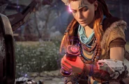 Aloy looking at the override module.