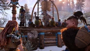 Aloy listening to a story told by a Matriarch.