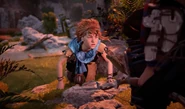 Aloy climbing to safety.