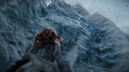 Aloy looking at the wall, wondering how they're going to climb it.