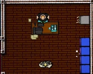 Jake sits at a desk moments before being shot by the Manager.