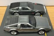 A side view of the Hot Wheels 1981 DeLorean DMC12 (2021 Boulevard, front) and Hot Wheels 1981 DeLorean DMC12 (2014 Speed Team, back)