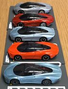 A side view of the McLaren Speedtail from front to back: Hot Wheels metalflake light blue, Tomica orange (1/68), Tomica gray-blue (1/68), Hot Wheels metalflake orange, Hot Wheels metalflake gray