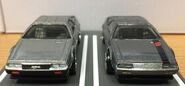 A front view of the Hot Wheels 1981 DeLorean DMC12 (2021 Boulevard, left) and Hot Wheels 1981 DeLorean DMC12 (2014 Speed Team, right)