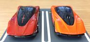 A back view of the metalflake orange Hot Wheels McLaren Speedtail (left) and the orange Tomica McLaren Speedtail (right, 1/68)