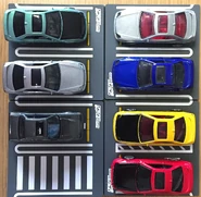 Counterclockwise from upper right. A top view of the 2020 Hot Wheels ’98 Honda Prelude silver, 2020 dark blue, 2021 yellow, and 2021 red. Bottom left, the 2017 Tomica Limited Vintage NEO ’85 Honda Prelude 2.0 Si (1/64), the 2021 Hot Wheels ’98 Honda Prelude metalflake silver (car culture, modern classics) and 2021 seafoam green (Dollar General Exclusive).