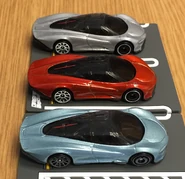A side view of the Hot Wheels McLaren Speedtail from front to back: metalflake light blue, metalflake orange, metalflake gray