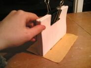 5. Glue the spine to the middle of the piece of plain fabric. Press the fabric with your finger-tip so that it is firmly against the spine of the pages.