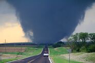 The violent EF4 crossing a road before destroyng a house and barn