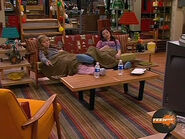 Carly and Sam share a blanket on the couch.