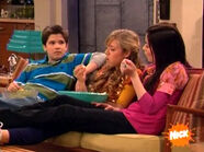 Carly resting her feet on Sam's legs and the two share popcorn