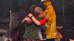 Carly leans on Sam in an embrace for support after her room is burned down